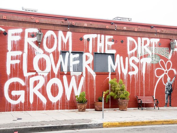 Graffiti street art on red wall with white drawing in Los Angeles