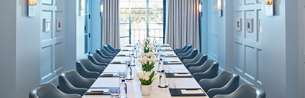 Long table and chairs set up in a blue meeting room