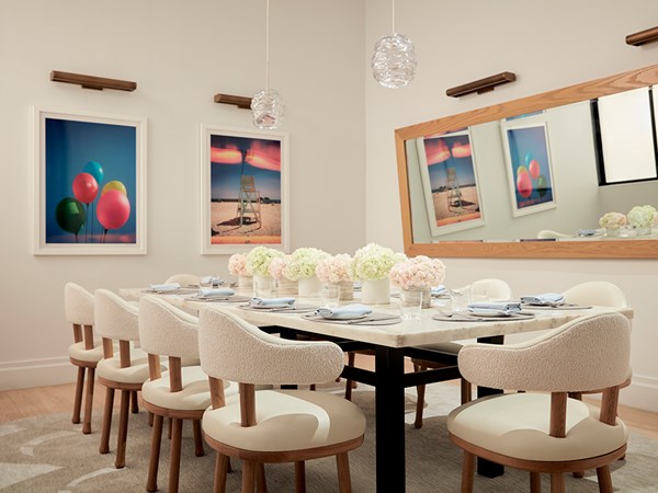 White private dining table with pink and orange flowers on top