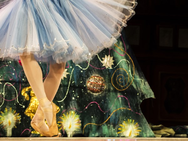 Ballerina in a blue tutu with Christmas tree backdrop