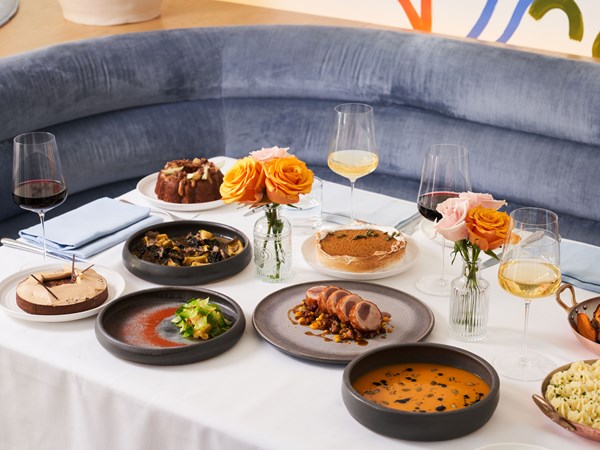 Thanksgiving meal on a table with a blue upholstered banquette