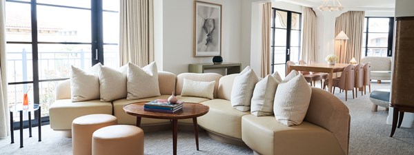 Large L-shaped beige sofa with beige cushions in living area of suite