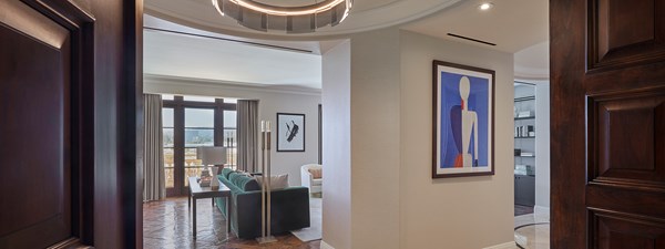 Entrance to The Residence with dark mahogany door, modern artwork on the walls and floor to ceiling windows