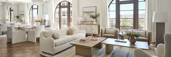 Large open-plan living space with a cream and nude colour palette and double balcony doors