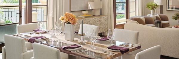 Dining room table in open-plan living area of the Three-bedroom Residence, decorated with glassware and dark purple tableware